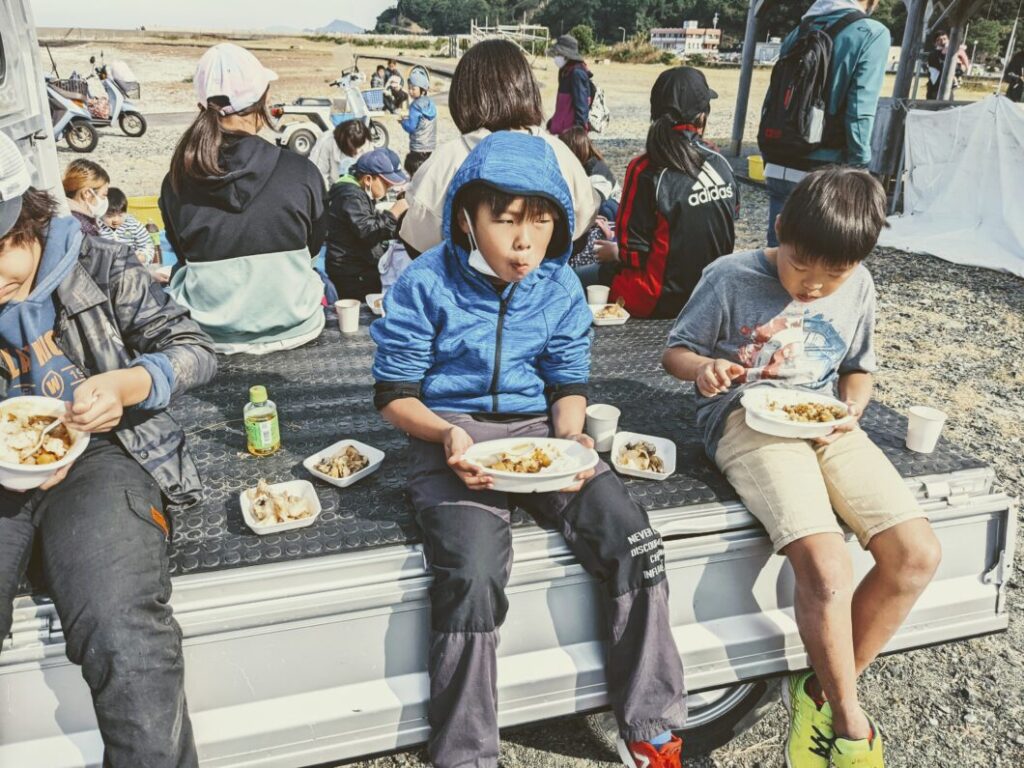 釣り大会の昼食でカレーライスを食べる子どもたち2