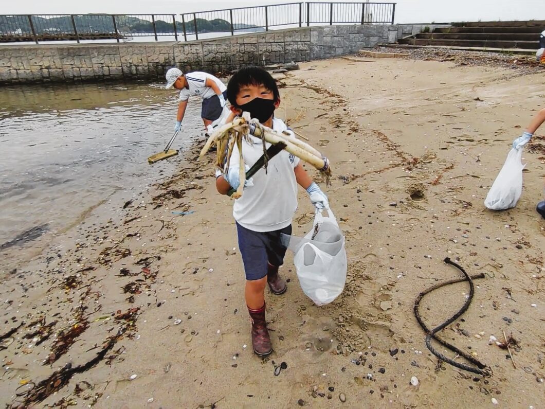 人工島海岸清掃でゴミを拾う児童